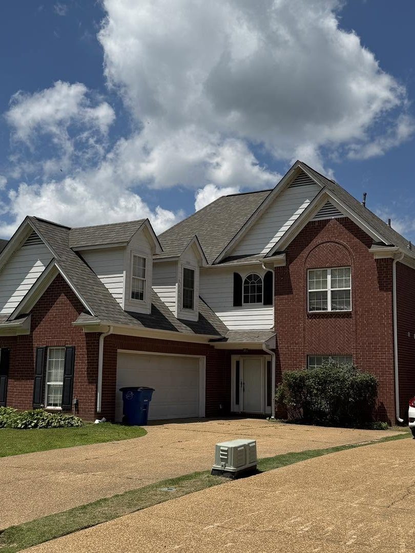 A new shingle roof and gutters on a red barn by Custom Remodeling